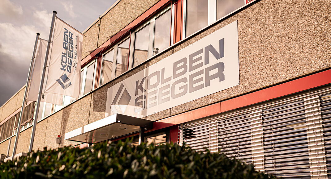 Eingangsbereich der Kolben-Seeger Firmenzentrale in Steinbach im Taunus mit Firmenlogo und Fahnen seitlich unten